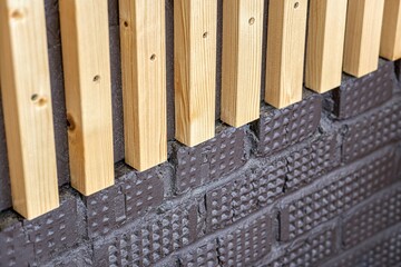 Wall Mural - Building wall decorated with stylish wooden slats made of thin light planks on house terrace extreme close view