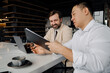 © Drobot Dean - Midaged asian businessman showing clipboard with documents to his smiling partner