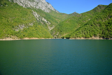 Albania, Lake Koman is a reservoir on the Drin River in northern Albania, surrounded by dense forested hills, vertical slopes, deep gorges and a narrow valley