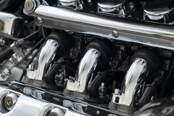 Engine parts motorcycle intake manifold made of chrome-plated metal, spare parts. Close-up, selective focus, no people, horizontal orientation