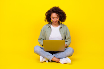 Poster - Full size photo of cute young girl wavy hair use laptop it specialist coder dressed stylish khaki look isolated on yellow color background