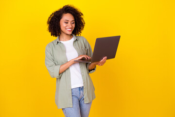 Poster - Photo of boss wavy young brunette lady look laptop wear grey shirt jeans isolated on yellow color background