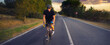 © Solid photos - Young sports man cycling with bicycle on the road in summer