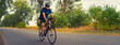 © Solid photos - Young sports man cycling with bicycle on the road in summer