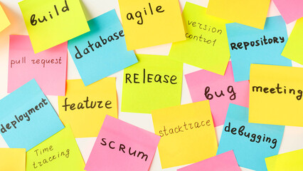 multi-colored square stickers with terms from the it field - release, bug, meeting, feature, databas