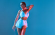 © Georgii - Isolated sexy attractive fit woman over blue background enjoying dance. Dynamic lifestyle of youth.