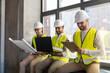 © Syda Productions - architecture, construction business and people concept - male architects in helmets with laptop, blueprint and clipboard working at office