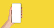 © valiantsin - Banner with hand holding phone mockup on yellow background. Smartphone template. Copy space. High quality photo