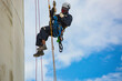 © chitsanupong - Male worker inspection wearing safety first harness rope safety line working at a high place on tank roof spherical gas  blue sky