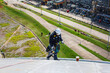 © chitsanupong - Male worker inspection wearing safety first harness rope safety line working at a high place on tank roof spherical gas
