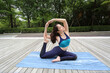 © FotoArtist - Young sporty attractive woman practicing yoga, doing yoga exercise with friend, yoga pose, working out, wearing sportswear, pants and top, outdoor full length