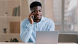African american man businessman freelancer worker talk chatter on mobile cellphone with client make business call discussion listen news explain information looks at laptop screen use gadget service