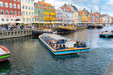 Nyhavn Is A Sightseeing And Entertainment District With Its Canal And Colorful Houses And Old Ships. Tourists Taking A Canal Tour With A Sightseeing Boat. 19 July 2022 Copenhagen, Denmark 