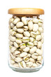 Organic pistachio nut full fill in glass bottle with wood cap on transparent background