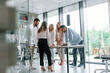© standret - Standing by the table near big windows. Group of professional business people is in the office