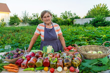 Senior Woman Preserving Vegetables In Jars. Selective Focus.