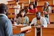 © AnnaStills - Group of students listening to teacher during lecture at university