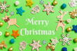 Leinwandbild Motiv Merry Christmas text. Top view of green background with New Year toys and decorations. Christmas time concept with copy space