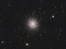 Messier 13 Globular Cluster In Hercules Constellation, With Many Stars As Background And A Galaxy On The Left.