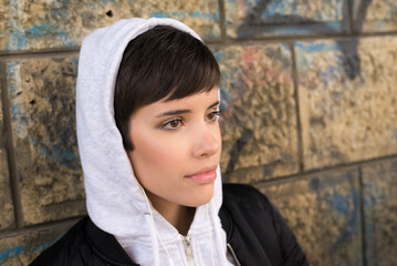 Wall Mural - Portrait of young woman outdoors wearing hoodie