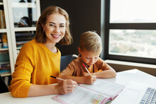 Cheerful Mother Doing Homework With Son At Home