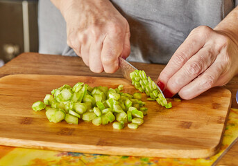 Wall Mural - Chef cuts the asparagus into small pieces to prepare the dish