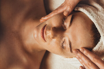 Wall Mural - caucasian freckled woman having a facial massage beauty treatment. natural woman beauty, skincare. b