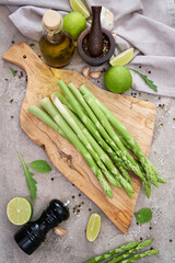 Wall Mural - Green organic natural Asparagus on wooden cutting board at kitchen table