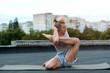 © Ludaiv - A man practices yoga on the roof of the house. Yoga at sunset. Healthy life, sport and meditation concept.