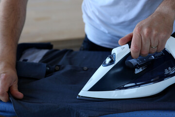 man ironing his shirt for work