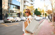© Camerene P/peopleimages.com - Stylish fashion model shopping in the city and walking outdoors with bags. Young, edgy and carefree female with an expensive lifestyle standing in the street with bags in an urban town