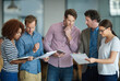 © Arcurs Co-op/peopleimages.com - Colleagues talking about paperwork while standing in the office together. Business people working together to discuss strategy while using wireless devices. Tech savvy ways to save time in your job.