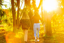 Two Teen Girls Walking Away Into Golden Light And Sun Flare
