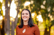 © Austockphoto - head and shoulders of smiling confident young woman outdoors