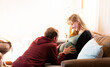 © Austockphoto - Young husband touching wife's pregnant belly - lifestyle maternity