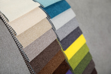 Wall Mural - Catalog of colorful fabric samples on grey background, closeup