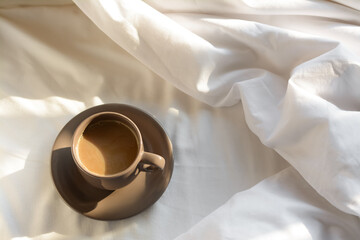 Wall Mural - Aromatic morning coffee on bed, above view. Space for text