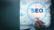 © chaylek - Marketer hold a light bulb showing SEO concepts, optimization analytics tools, search engine rankings, social media sites based on results analytics data. Customers use keywords to connect products