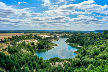 Naklejka na meble Aerial view of a lake in the mining of an open pit for sand and quartz in a forest area in the north of Germany
