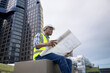 © Basicdog - African male civil engineer inspects a commercial building construction site in a real estate project.