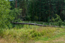 Landscape With Forest River And Old Wooden Bridge Across The It.