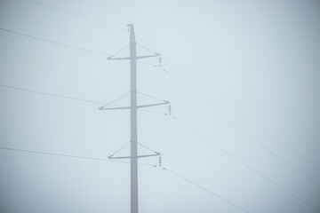 The power line is in the fog. Electrification. High voltage. A mystical place.