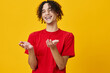 © SHOTPRIME STUDIO - Laughing cheerful funny Caucasian young man in red t-shirt posing isolated on over yellow studio background. The best offer with free place for advertising. Emotions for everyday concept