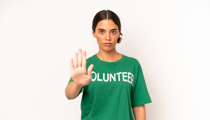 Wall Mural - pretty hispanic woman looking serious showing open palm making stop gesture. ecology and volunteer concept