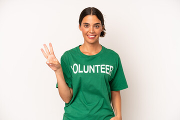 Wall Mural - pretty hispanic woman smiling and looking friendly, showing number three. ecology and volunteer concept