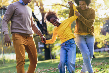 Happy family mother father and daughter on autumn walk in the park