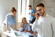 © NDABCREATIVITY - Working on new project together. Group of happy business people cooperating as a team in office
