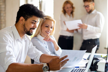 Wall Mural - Group of happy multiethnic business people cooperating, working on meeting in corporate office