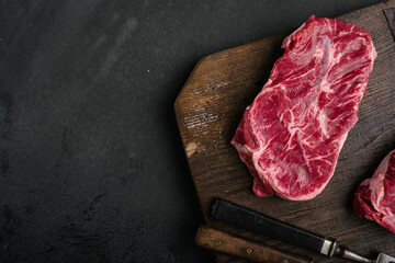 Wall Mural - Raw fresh meat Top Blade steaks, on black dark stone table background, top view flat lay, with copy space for text