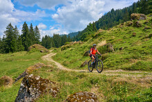 Nice Senior Woman Riding Her Electric Mountain Bike In The Bregenz Forest Mountains Near Hittisau, Vorarlberg Austria


